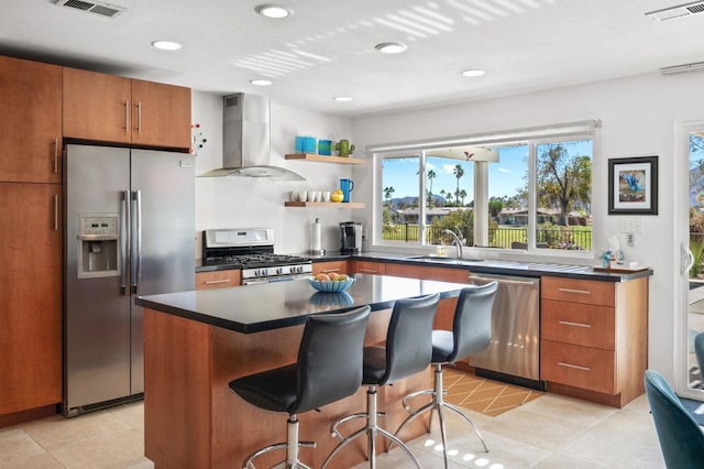 kitchen featuring sink, ventilation hood, a kitchen breakfast bar, a kitchen island, and stainless steel appliances