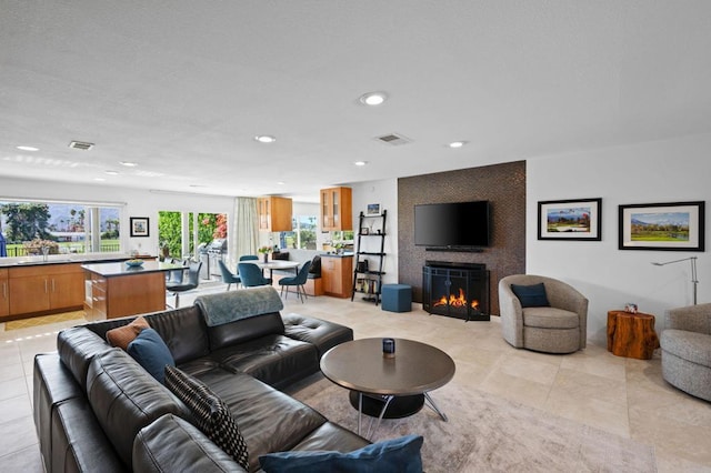 tiled living room with a large fireplace and sink