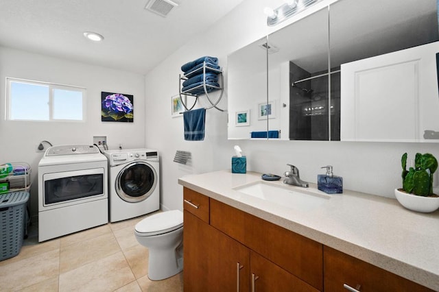 bathroom with a shower, vanity, independent washer and dryer, toilet, and tile patterned floors