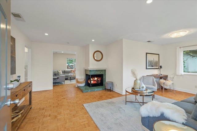 living room featuring plenty of natural light, a premium fireplace, and light parquet floors