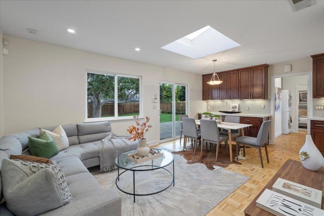 living room featuring light parquet floors and a skylight