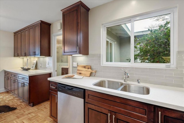 kitchen featuring dishwasher, sink, light parquet flooring, and decorative backsplash