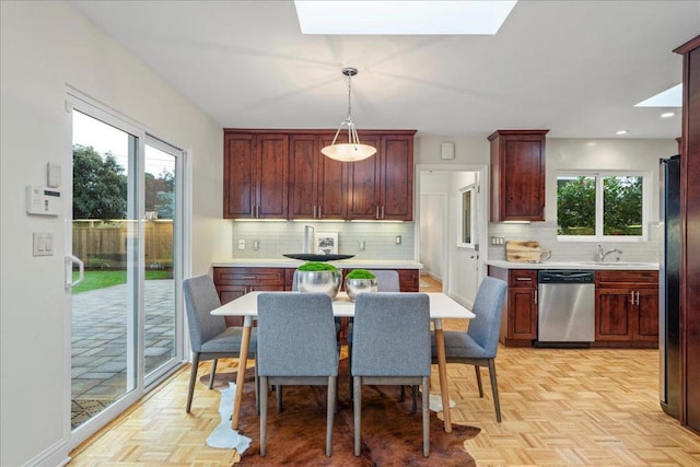 kitchen with hanging light fixtures, appliances with stainless steel finishes, light parquet floors, and sink