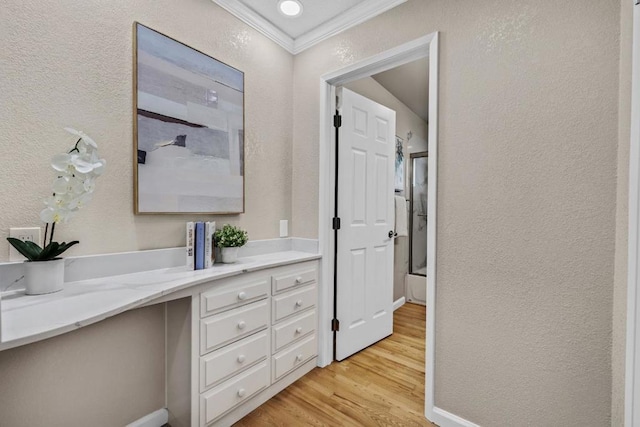 bathroom featuring hardwood / wood-style flooring, ornamental molding, vanity, and enclosed tub / shower combo