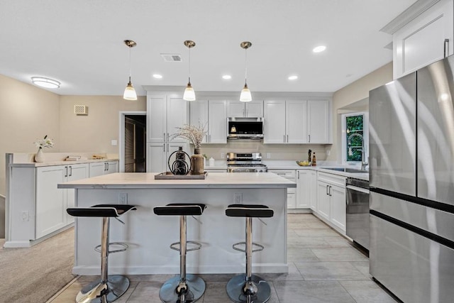 kitchen with white cabinetry, appliances with stainless steel finishes, sink, and hanging light fixtures