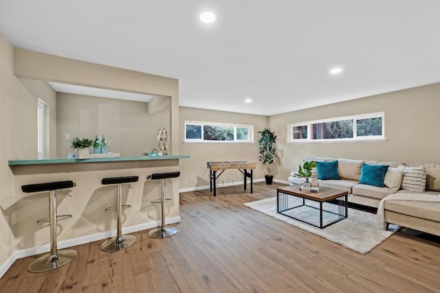 living room featuring bar and light wood-type flooring