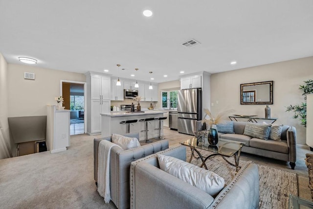 carpeted living room with sink