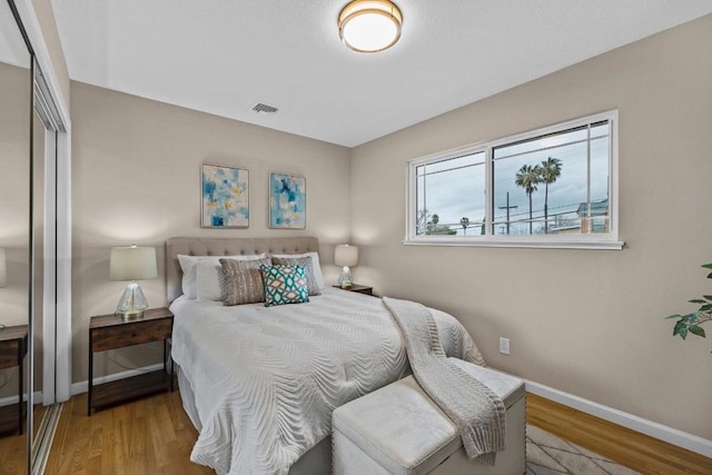 bedroom with light hardwood / wood-style floors and a closet