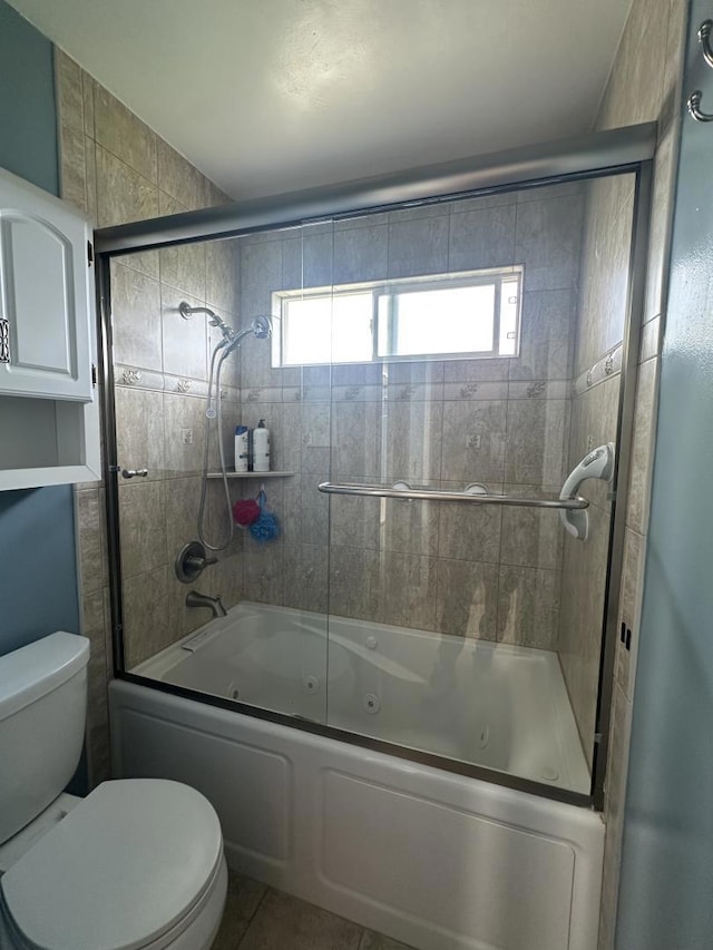 bathroom featuring enclosed tub / shower combo, tile patterned floors, and toilet