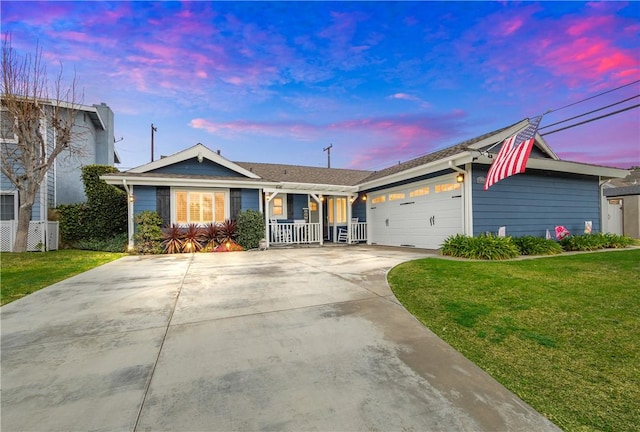 ranch-style home with a yard, covered porch, and a garage