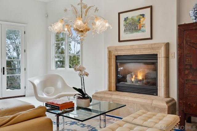 living area with a premium fireplace, plenty of natural light, and an inviting chandelier