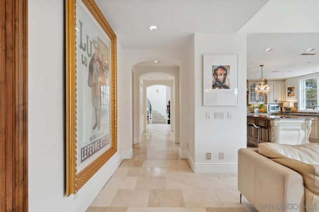 hallway featuring a notable chandelier