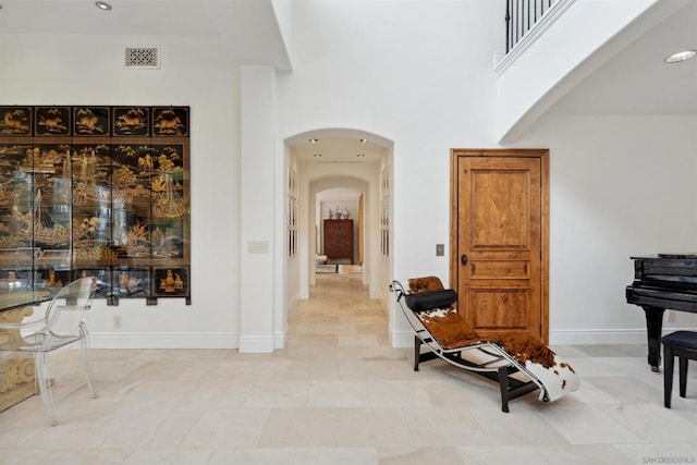 corridor featuring a towering ceiling