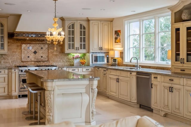 kitchen with a kitchen island, a breakfast bar, pendant lighting, appliances with stainless steel finishes, and sink