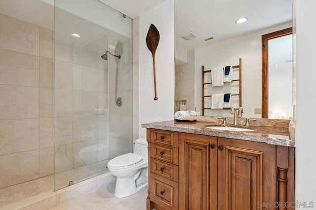 bathroom with vanity, a tile shower, and toilet