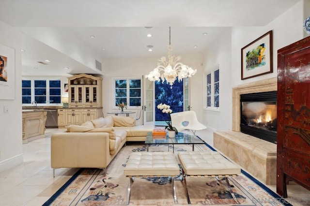 tiled living room featuring a high end fireplace, a chandelier, and sink