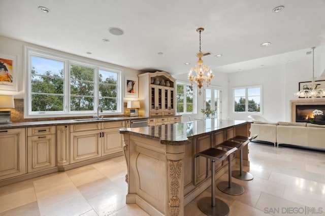 kitchen featuring sink, a breakfast bar, hanging light fixtures, a notable chandelier, and a kitchen island