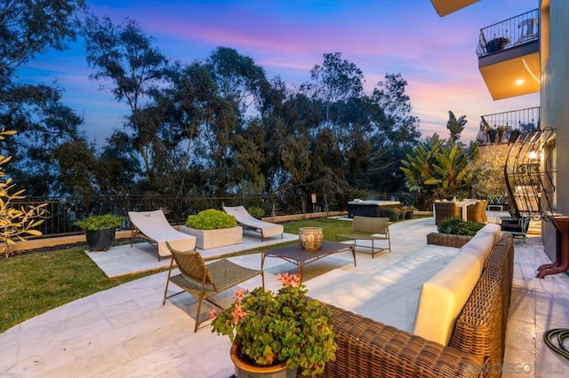 patio terrace at dusk with a balcony and outdoor lounge area