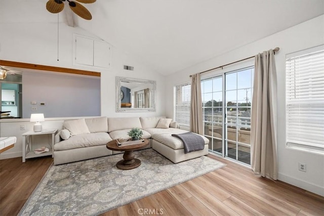 living room featuring ceiling fan, high vaulted ceiling, and light wood-type flooring