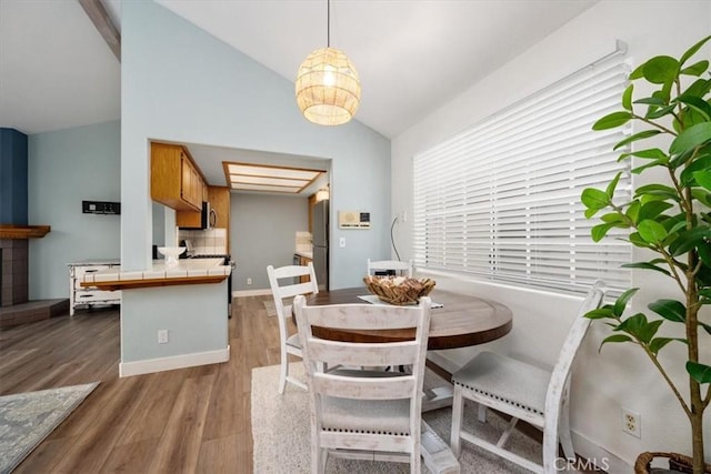 dining area featuring hardwood / wood-style floors and vaulted ceiling