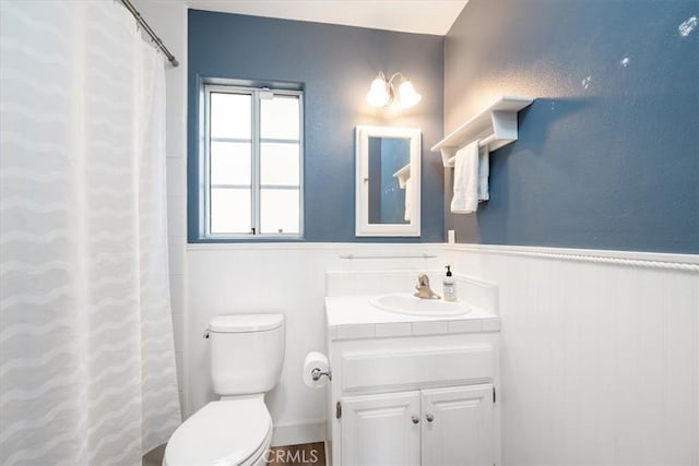 bathroom featuring walk in shower, vanity, and toilet