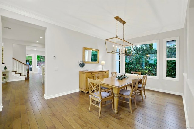 dining room featuring ornamental molding, dark wood-type flooring, and a notable chandelier