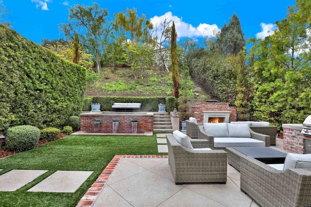 view of patio featuring an outdoor brick fireplace and area for grilling