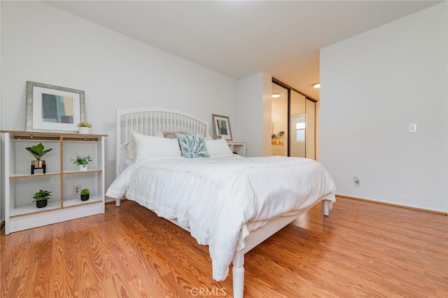 bedroom with hardwood / wood-style flooring and connected bathroom