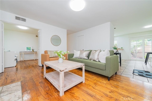 living room featuring washer / clothes dryer and light hardwood / wood-style floors