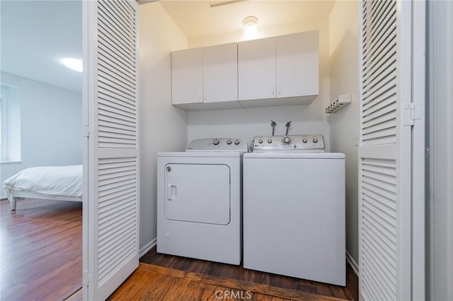 washroom with cabinets, dark hardwood / wood-style floors, and washer and clothes dryer