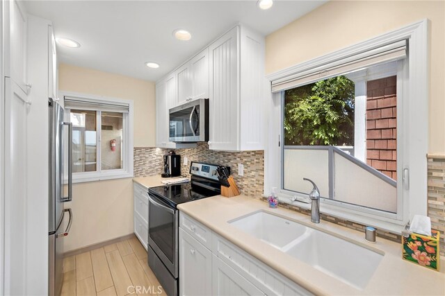 1051 Gaviota Dr, Laguna Beach, CA 92651 - kitchen with stainless steel appliances, plenty of natural light, tasteful backsplash, white cabinets, and recessed lighting