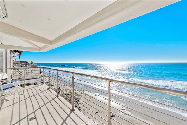 balcony with a water view and a beach view