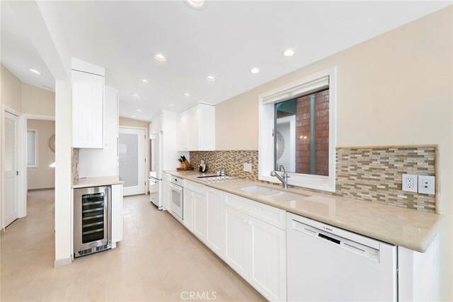 1051 Gaviota Dr, Laguna Beach, CA 92651 - kitchen featuring white appliances, beverage cooler, backsplash, white cabinetry, and recessed lighting