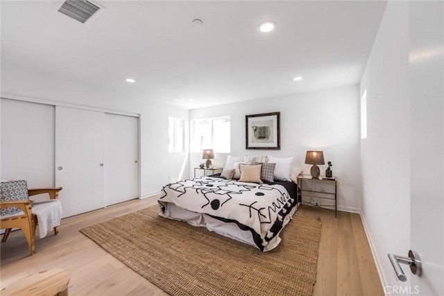 bedroom with light hardwood / wood-style floors and a closet