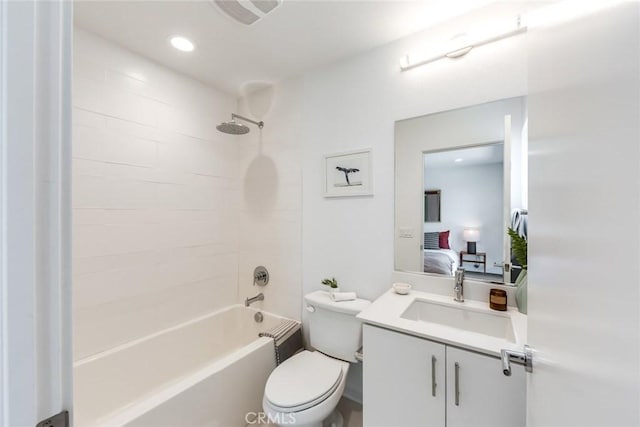 full bathroom featuring tiled shower / bath, vanity, and toilet