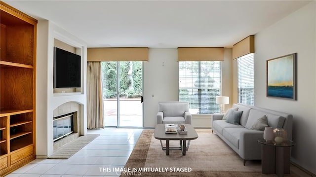 living room with light tile patterned floors, plenty of natural light, and a tile fireplace