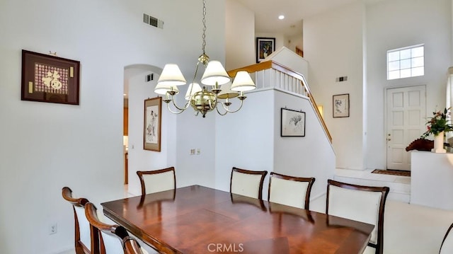 dining area featuring a notable chandelier and a high ceiling