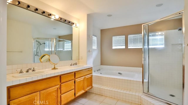 bathroom with tile patterned flooring, vanity, and separate shower and tub