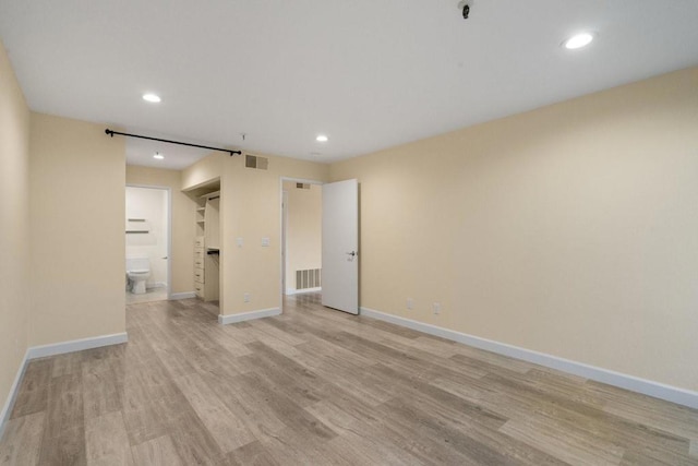 empty room featuring a barn door and light hardwood / wood-style floors