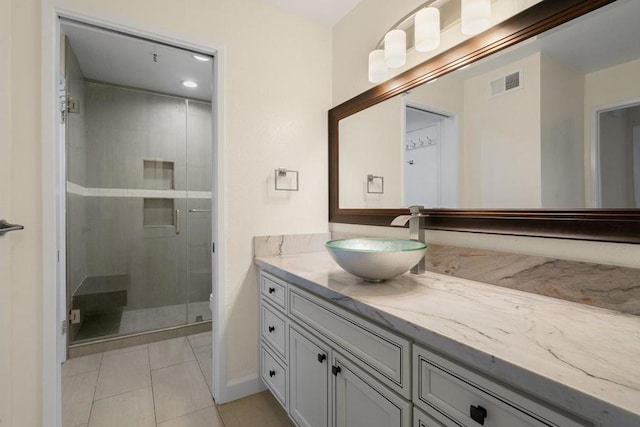 bathroom with vanity, a shower with shower door, and tile patterned flooring