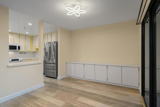 kitchen featuring electric stove, white cabinets, light hardwood / wood-style floors, and stainless steel fridge with ice dispenser