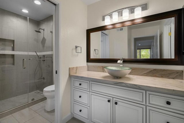 bathroom with vanity, tile patterned flooring, a shower with door, and toilet