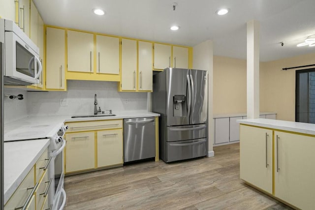 kitchen featuring stainless steel appliances, sink, and light hardwood / wood-style flooring