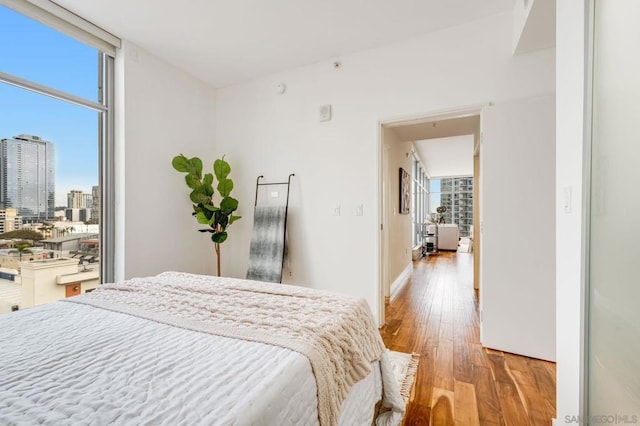 bedroom featuring floor to ceiling windows and light wood-type flooring