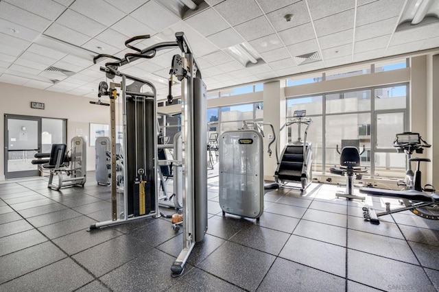 exercise room featuring expansive windows and a paneled ceiling