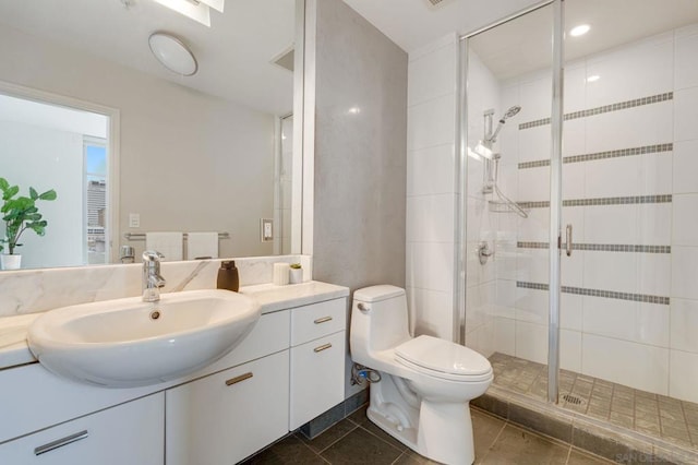 bathroom with vanity, tile patterned flooring, a shower with door, and toilet