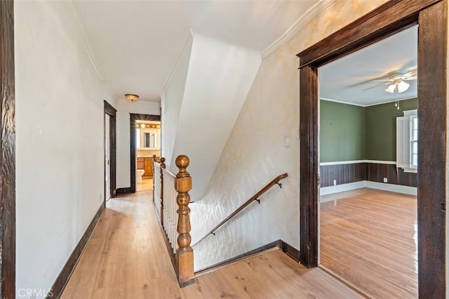 stairs featuring crown molding, wood-type flooring, and ceiling fan