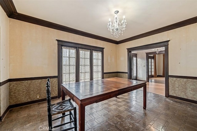 unfurnished dining area featuring crown molding, a wealth of natural light, and a chandelier