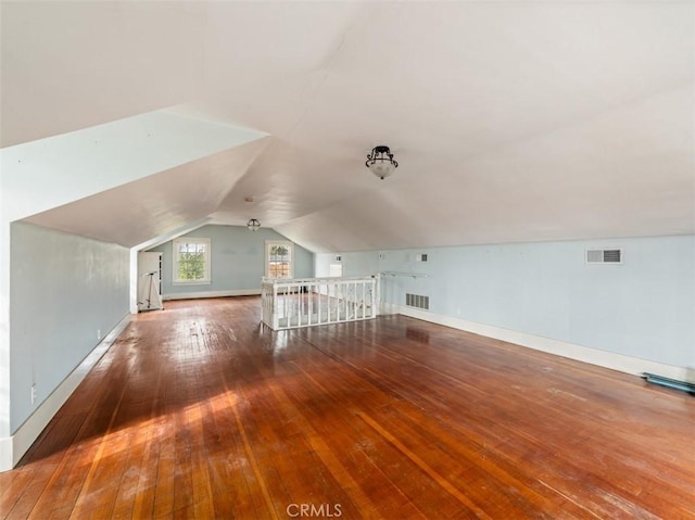 additional living space featuring hardwood / wood-style flooring and vaulted ceiling