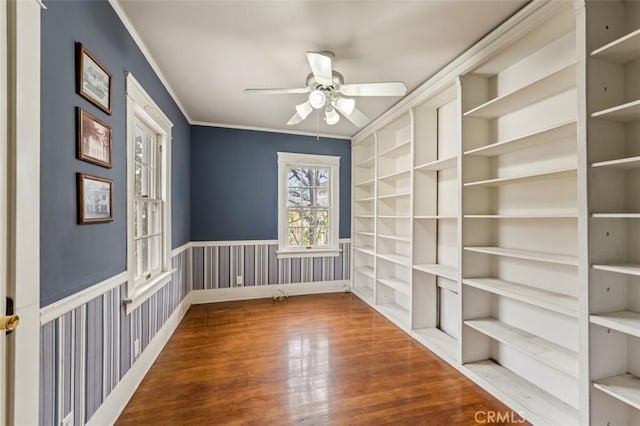 spare room featuring crown molding, wood-type flooring, and ceiling fan